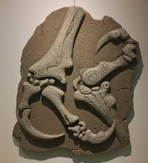 A relief sculpture of dinosaur fossils, including feet and claws.